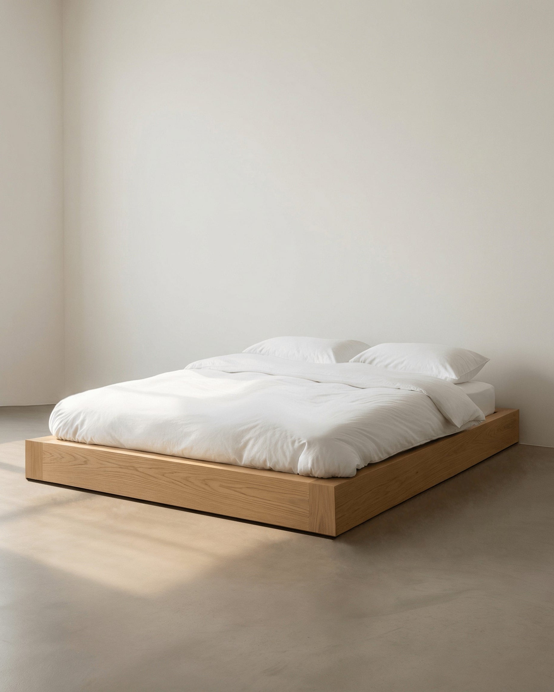 Minimalist wooden bed with white bedding in a plain room