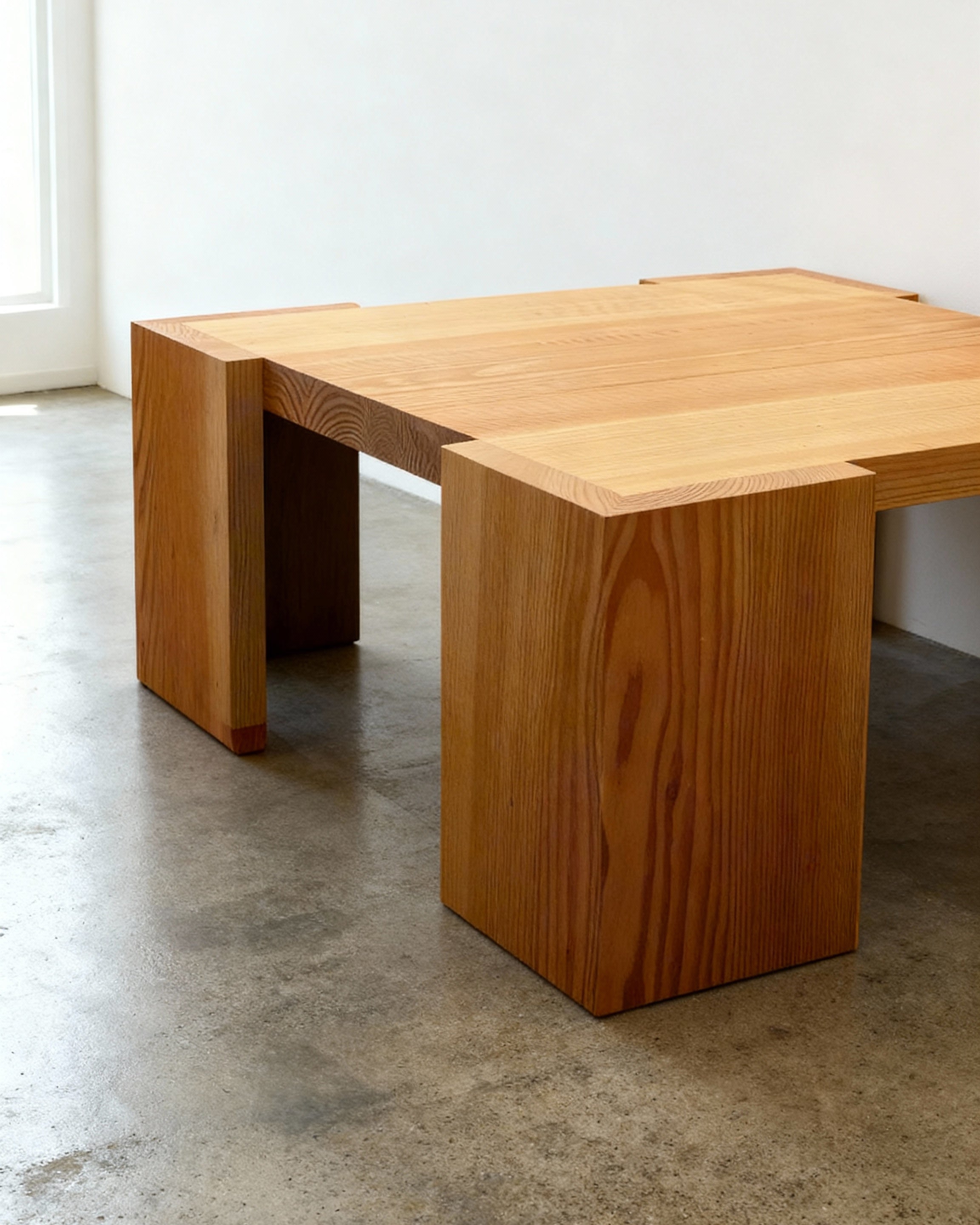 Wooden coffee table on a concrete floor with a white wall background